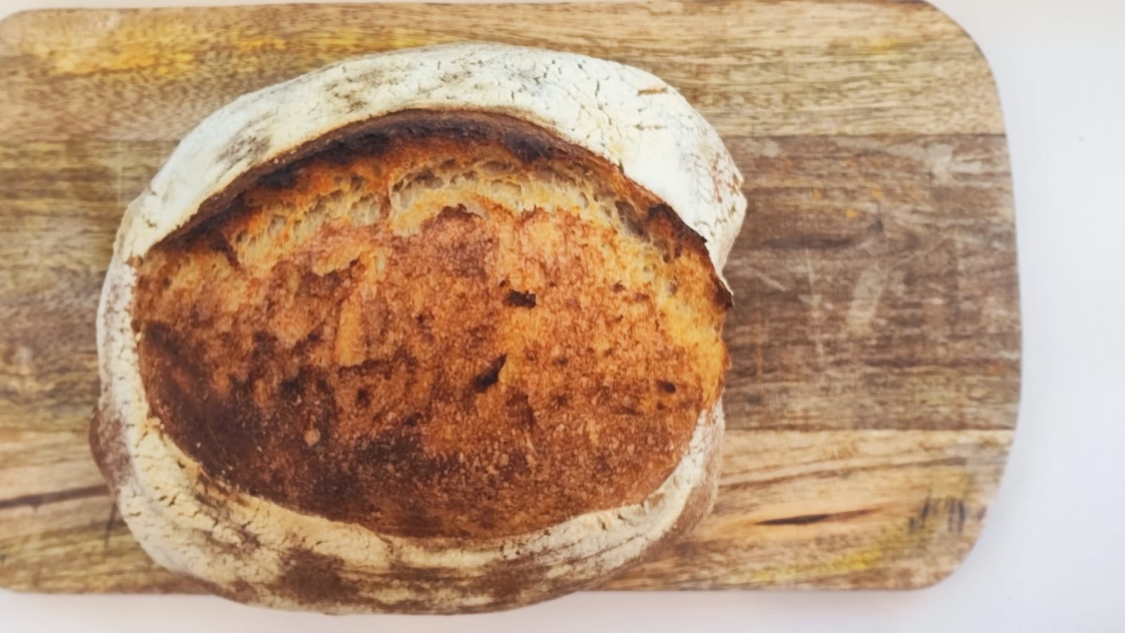 Finished sourdough loaf on a wooden board